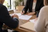 Des adultes d’une famille examinent un acte générique avec une notaire