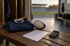 Un maillot et un ballon de rugby génériques reposent près d’un contrat illisible et d’une calculatrice éteinte