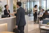 Une hôtesse d’accueil reçoit un visiteur tandis qu’une office manager coordonne le bureau.